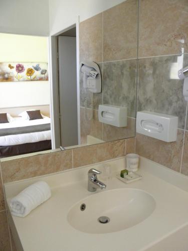 une salle de bain avec un lavabo et un miroir dans l'établissement Logis Hôtel Restaurant Le Mas de Mon Père, à Saint-Jean-le-Centenier