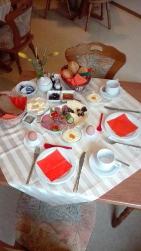 a table with plates and bowls of food on it at Christel's Pension in Brandenburg an der Havel