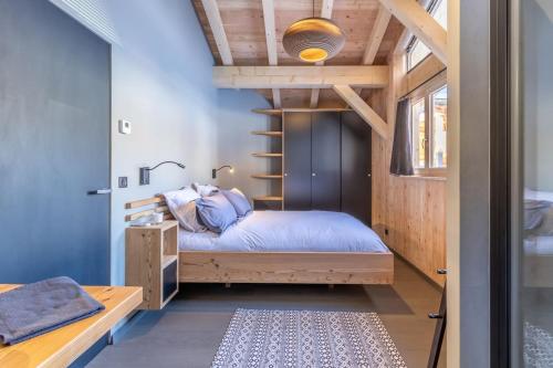 a small bedroom with a bed and a staircase at Chalet Béla Vya in Arc 1600