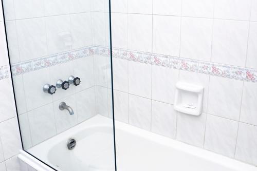uma casa de banho com um chuveiro, uma banheira e um lavatório. em Hotel Austral Bahía Blanca em Bahía Blanca