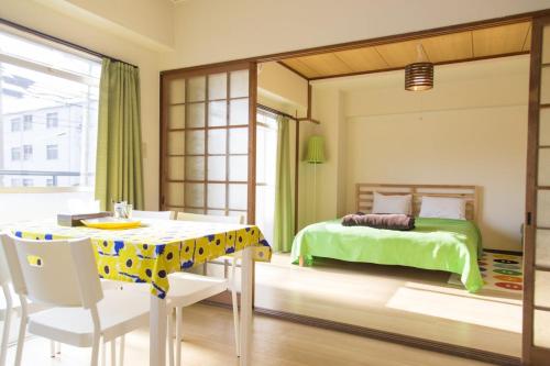 a bedroom with a bed and a table and chairs at Simple Stay Beppu in Beppu