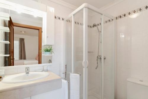 a white bathroom with a shower and a sink at Ilhéus III by An Island Apart in Funchal