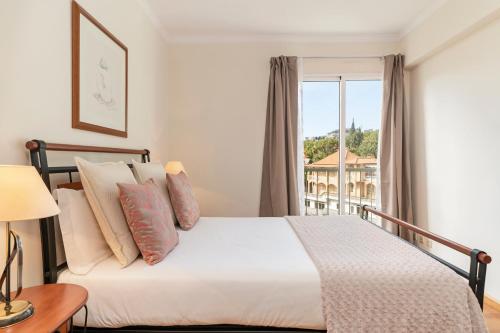 a bedroom with a bed and a large window at Ilhéus III by An Island Apart in Funchal