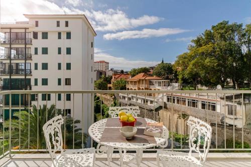 a table with a bowl of fruit on a balcony at Ilhéus III by An Island Apart in Funchal