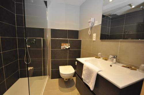 a bathroom with a sink and a toilet and a shower at Auberge de la Paix in Briançon