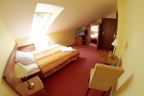 Habitación de hotel con cama y ventana en Pensjonat Żagielek, en Augustów