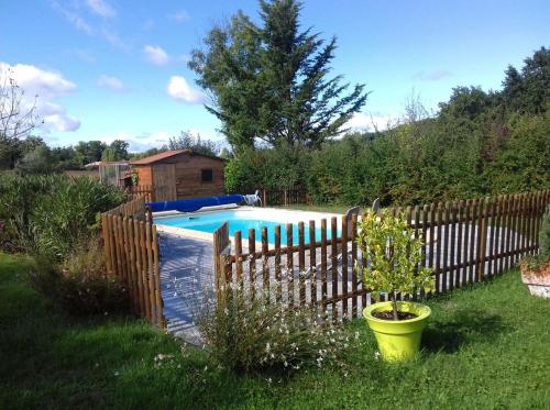 a wooden fence around a swimming pool in a yard at 2 chambres lit140 et 2lits 90 dans villa10mn ligue de foot 13mn clinique l union 18mn golf Palmola in Lapeyrouse-Fossat