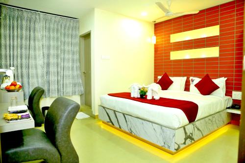 a bedroom with a bed and chairs in a room at HOTEL KEK GRAND PARK in Chennai