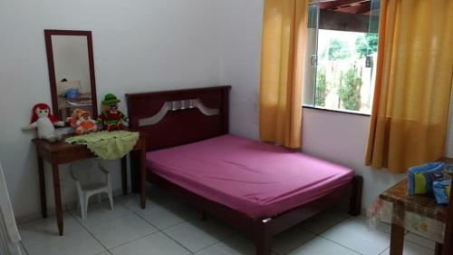 een slaapkamer met een bed, een bureau en een spiegel bij Casa em Furnas-Capitólio in Furnas
