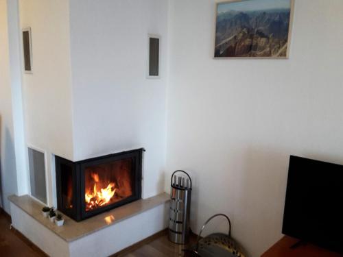 a fireplace in a living room with a fire in it at Apartmán SLAVKOV in Nová Lesná