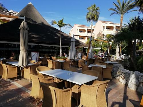 フエンヒロラにあるClub La Costa World Resortのテーブル、椅子、パラソルが備わるレストラン