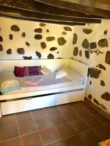a bunk bed in a room with rocks on the wall at La Alpispa in Valleseco