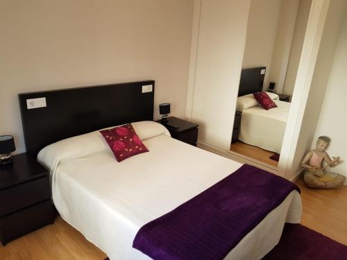 a small bedroom with two beds and a mirror at Piso en O Grove in O Grove