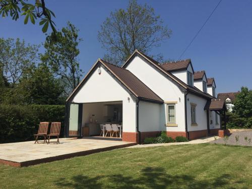 a house with a pitched roof and a patio at Country Retreat near Golf, Cotswolds, Stratford-Upon-Avon and Worcester in Bishampton