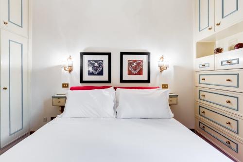 - une chambre avec un lit blanc et 2 oreillers rouges dans l'établissement Elegant Apartment Rome, à Rome