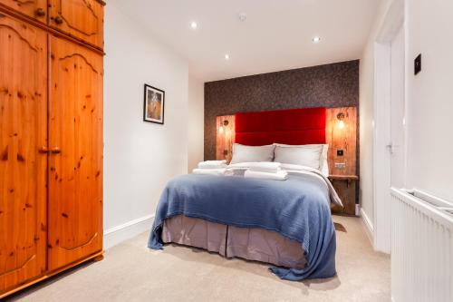 a bedroom with a large bed with a red headboard at Gorgeous Town Centre Apt with Courtyard Garden in Bournemouth