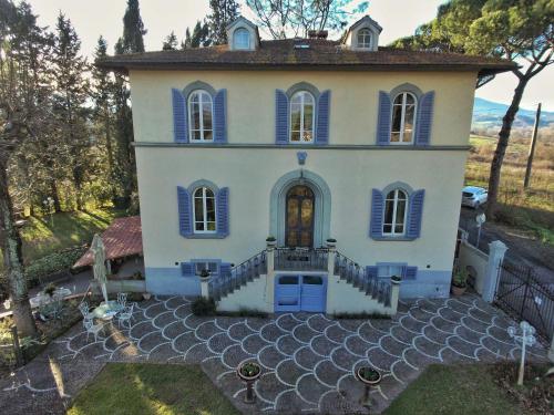 a large house with blue shutters on it at Relais Villa Al Vento in Incisa in Valdarno