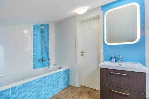 ein Badezimmer mit Badewanne, Waschbecken und Spiegel in der Unterkunft Dajla 66 in Dajla