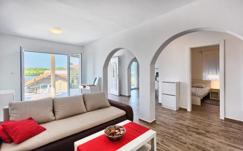 a living room with a couch and a table at Apartmani ATL in Rogoznica
