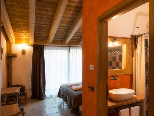 ein Bad mit einem Waschbecken und ein Bett in einem Zimmer in der Unterkunft Lo Tzeno in Fenis