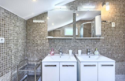 a bathroom with two sinks and a mirror at Apartmani ATL in Rogoznica