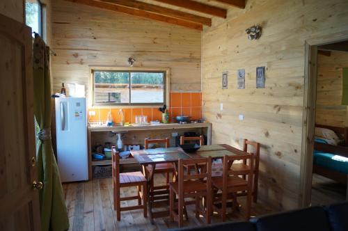 a kitchen and dining room with a table and a refrigerator at Rustico Pucon in Pucón