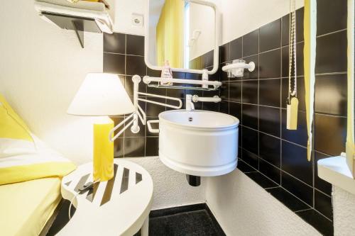 a small bathroom with a sink and a mirror at Hotel Tusculum in Marburg an der Lahn