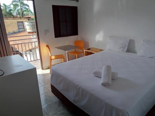 a bedroom with a white bed with two towels on it at Pouso do Rio in Pirenópolis