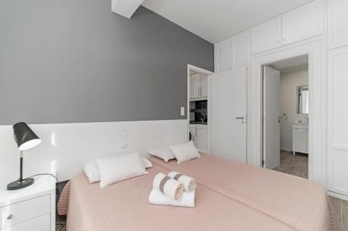 a white bedroom with two towels on a bed at Funchal City Apartments in Funchal