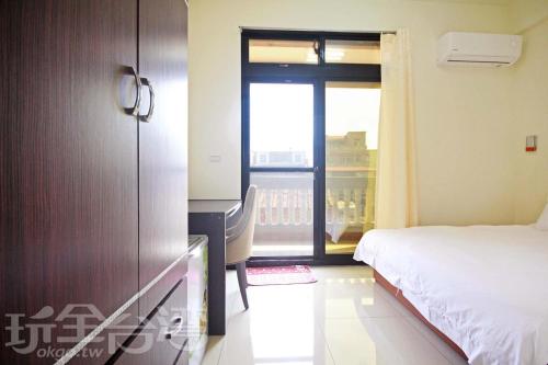 a bedroom with a bed and a desk and a window at 海豐民宿 Haifeng Bed and Breakfast in Jincheng