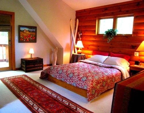 a bedroom with a bed and two tables and two windows at The Catskill Cabin in Elka Park