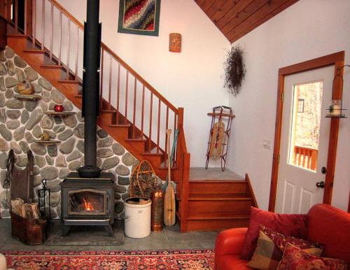 a living room with a fireplace and a staircase at The Catskill Cabin in Elka Park