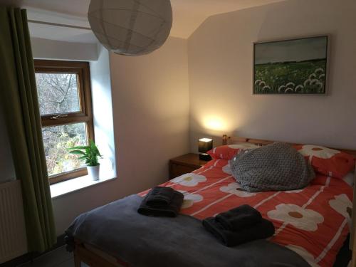 Un dormitorio con una cama con un edredón rojo y blanco. en No21 Hop to Zipworld, en Bethesda
