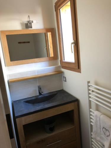 une salle de bain avec un lavabo et un miroir dans l'établissement Chalet Petite Etoile Des Neiges, à L'Alpe-d'Huez