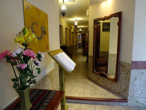 a hallway with a mirror and a vase of flowers at La Casa de Mia Mama in Salta