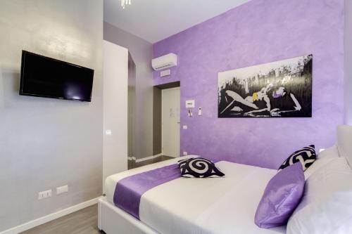 2 camas en una habitación con paredes moradas en B&B Colosseo Panoramic Rooms, en Roma