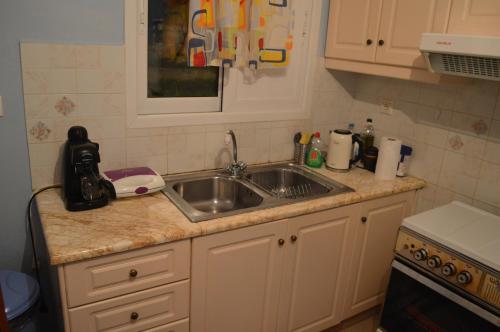 a kitchen with a sink and a counter top at Αpartment at the entrance of the city Dimitropoulos in Aigio