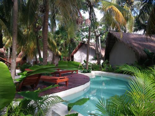 a resort with a pool and a deck and benches at Serena Tulum - Adults Only in Tulum