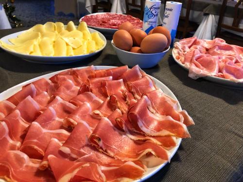 una tavola con piatti di cibo e ciotole di frutta di Hotel Amoha a Rimini