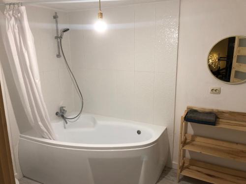 a white bath tub in a bathroom with a mirror at ГУЦУЛЬСЬКА ХАТА in Yasinya
