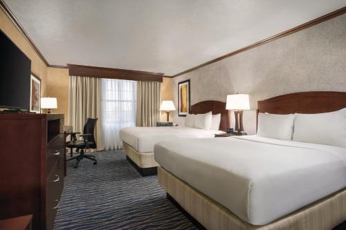 um quarto de hotel com duas camas e uma televisão em Radisson Salt Lake Airport em Salt Lake City