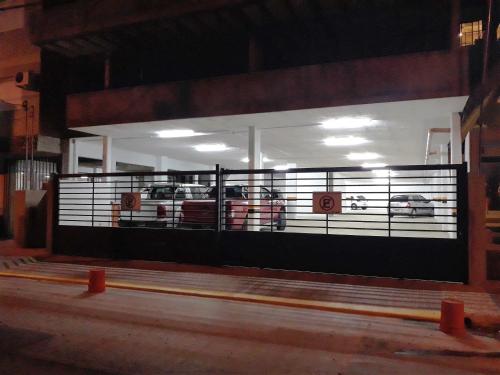 a gate in a building with cars in a garage at Victor Hotel in Villa Carlos Paz