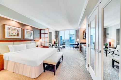 a hotel room with a large bed and a living room at Jet Luxury at The Signature Condo Hotel in Las Vegas