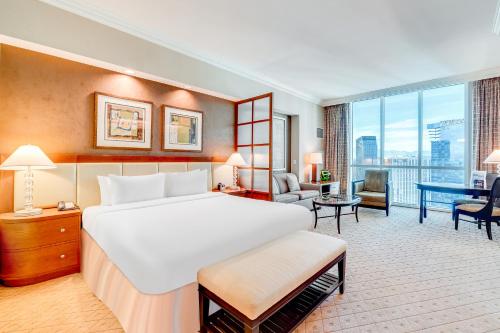 a hotel room with a large bed and a desk at Jet Luxury at The Signature Condo Hotel in Las Vegas