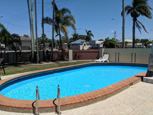 
a swimming pool with a pool table and chairs at Miners Lodge Motor Inn in Mackay
