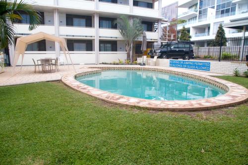 a swimming pool in a yard in front of a building at Cleveland Bay Air Motel in Cleveland