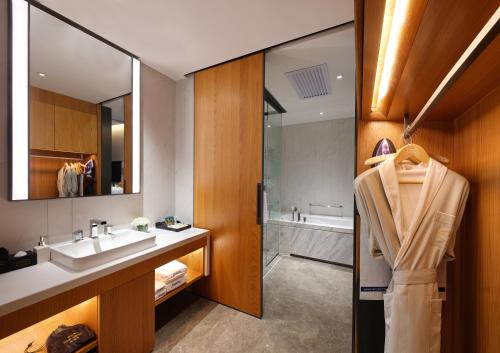 a bathroom with a sink and a bath tub at Hampton by Hilton Guangzhou Tianhe Sports Center-Free Shuttle Bus to Exhibition During Canton Fair Period in Guangzhou
