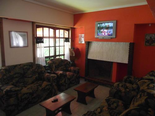 a living room with two couches and a fireplace at Hotel Sahara in Villa Gesell