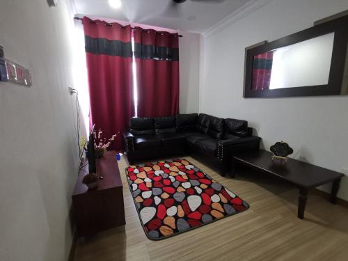 a living room with a black couch and a red curtain at Syahmi Homestay Melaka in Melaka