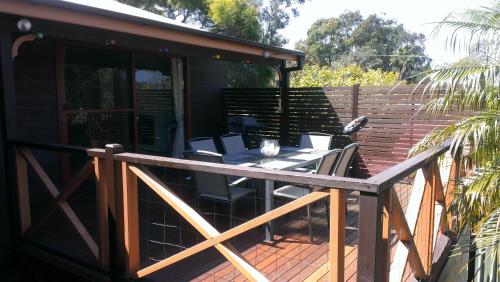 a patio with a table and chairs on a deck at Kincumber House in Kincumber